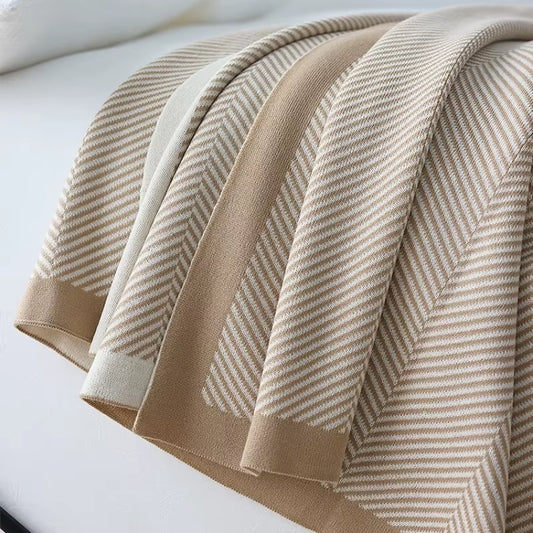 Close view of the khaki herringbone knit throw and its contrast border.