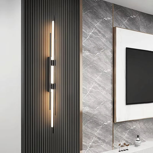 Linear black wall sconce lit on a slatted wall panel