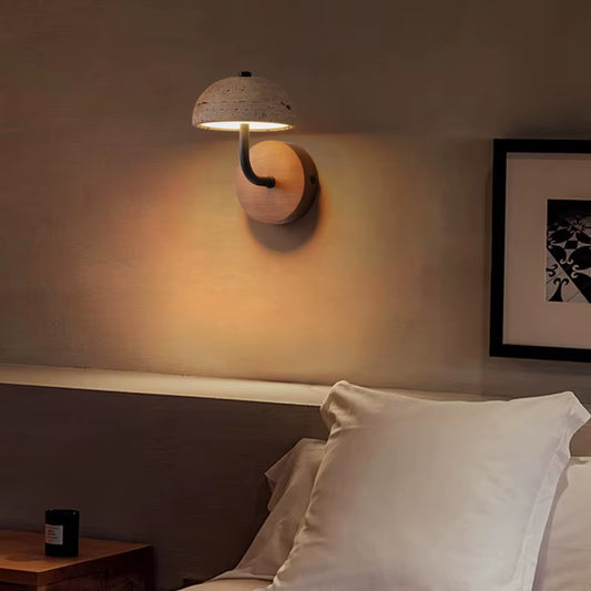 Travertine dome wall sconce lit above a bed