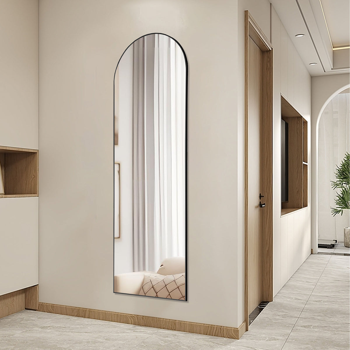 Arched full-length mirror with a thin black frame hung on a hallway wall.