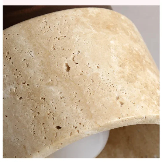 Close view of the pitted stone surface of the round ceiling light.