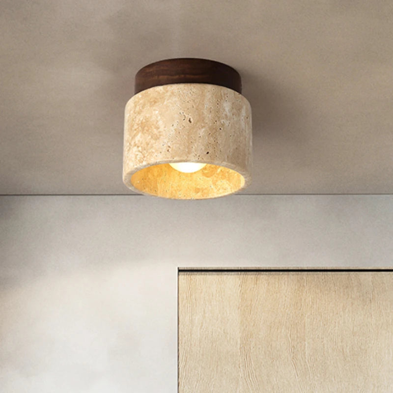 Round stone and wood ceiling light mounted on a ceiling, lit.