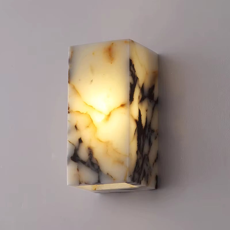 Stone block wall sconce, lit, on a gray wall.