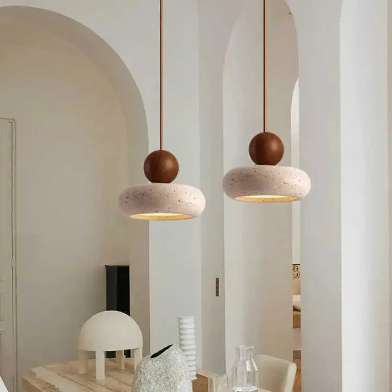 Two walnut-color pendant lights hanging in a white room with arched doorways.