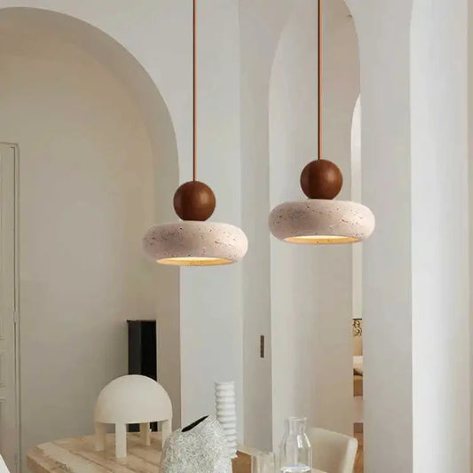 Two walnut-color pendant lights hanging in a white room with arched doorways.