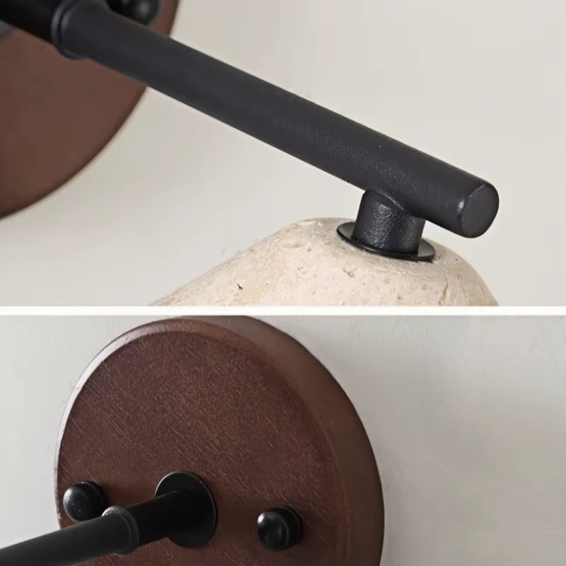Close views of the black iron arm and the dark wood backplate
