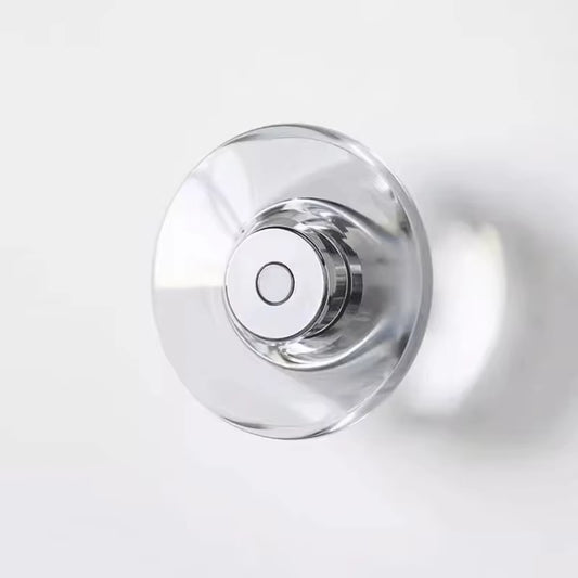 Clear crystal disc wall sconce on a chrome-color base, unlit, on a white wall.