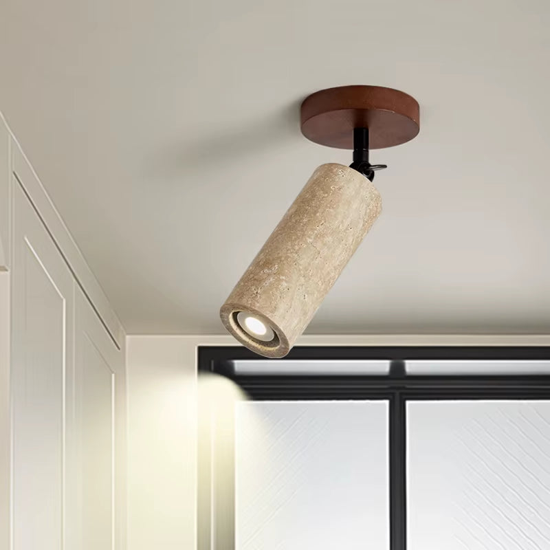 Travertine ceiling spotlight angled down from a ceiling, close view
