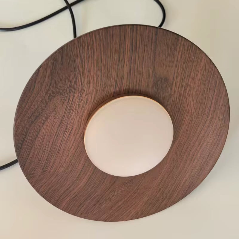 Close view from below of the walnut-grain shade and its white diffuser.