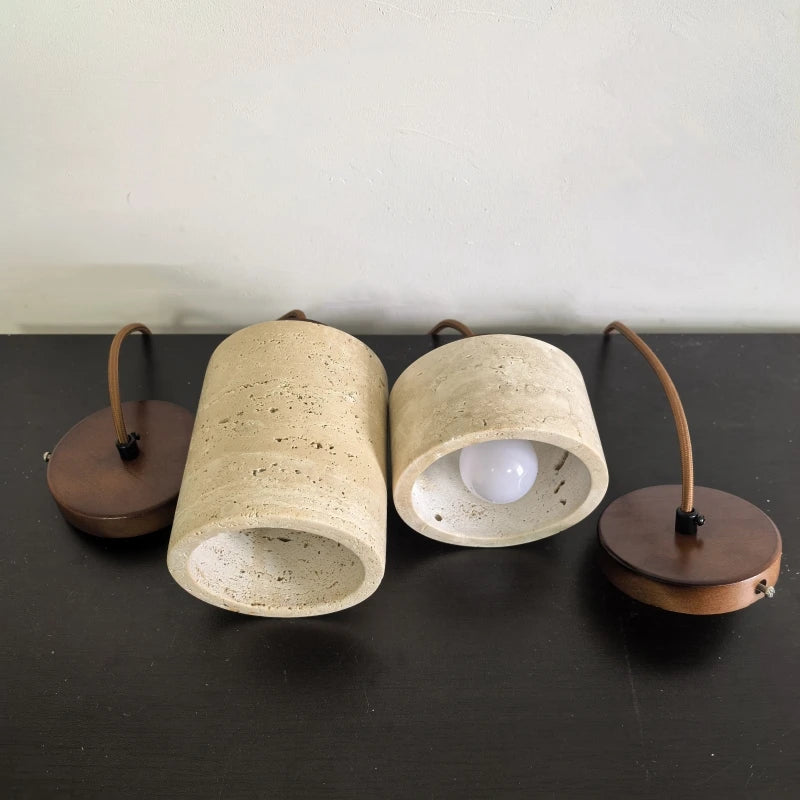 Travertine pendant shades laid on their sides, showing the open base and socket.