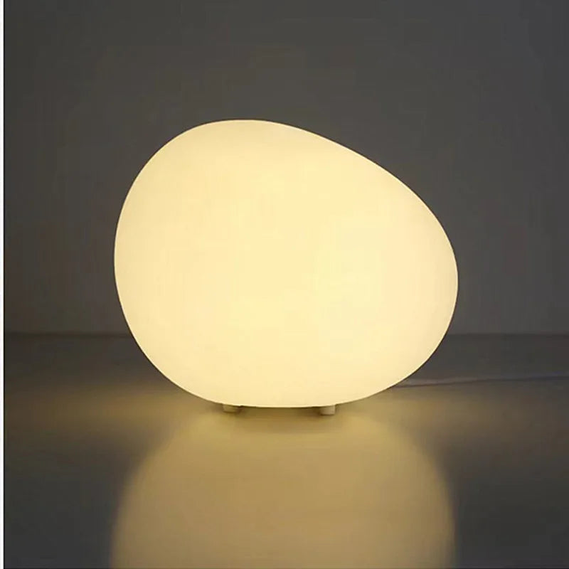 Pebble-shaped cobblestone table lamp glowing softly