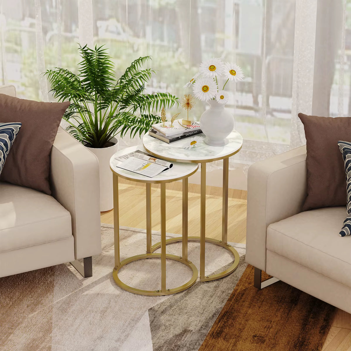 Nesting side tables with white tops and gold frames between two armchairs in a living room.