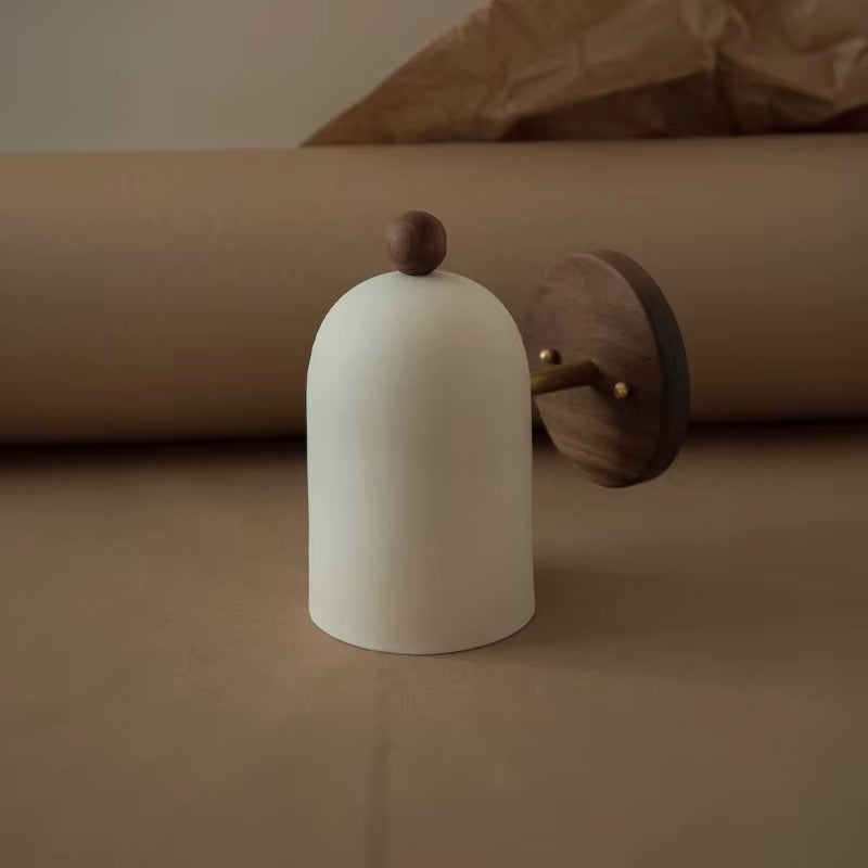 Round backplate wall sconce with a white bell shade, shown unmounted