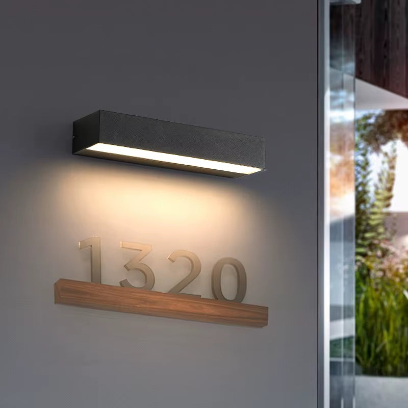 Black wash wall light above a house number