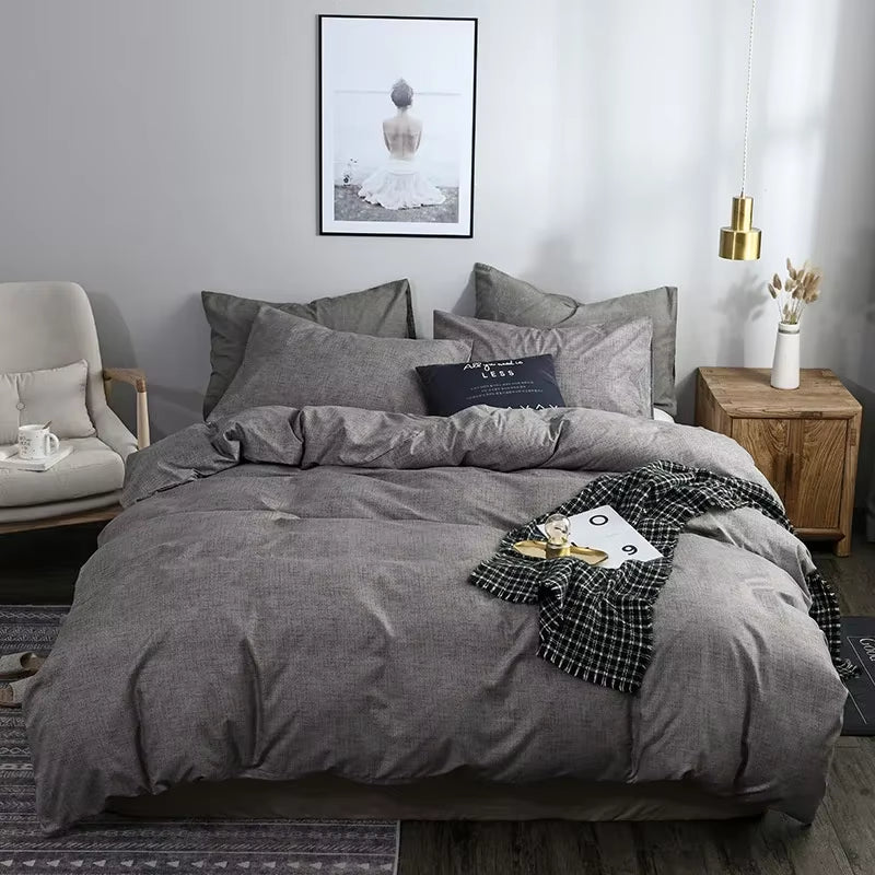Grey duvet cover set on a bed in a bedroom with a wooden nightstand.