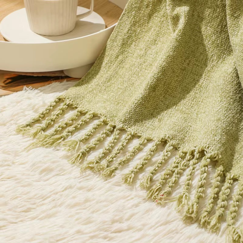 Close view of the knotted fringe on the matcha green chenille throw.
