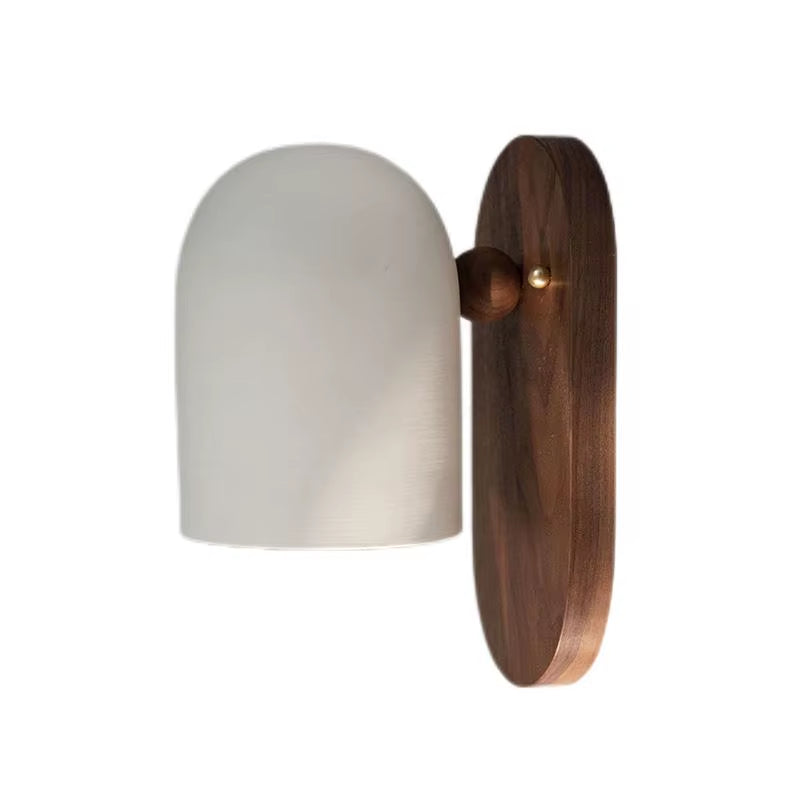 Oblong backplate wall sconce with a white bell shade on a white background