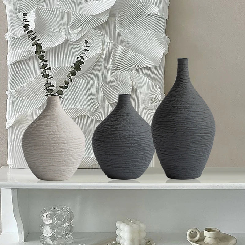 Beige and grey ribbed vases on a white shelf