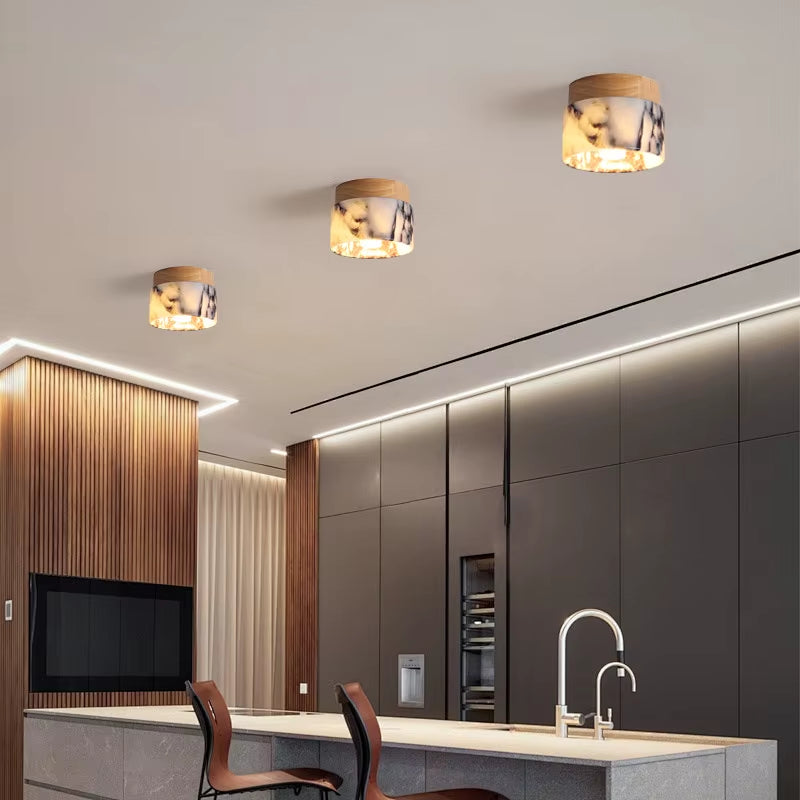Three marble flush mount ceiling lights above a kitchen island