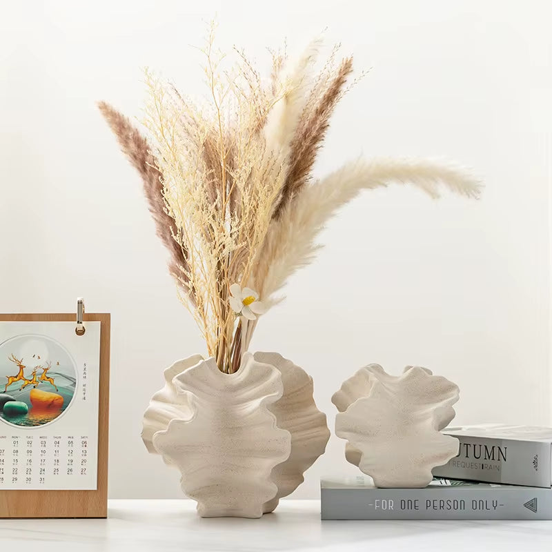 Two wave vases on a table with books