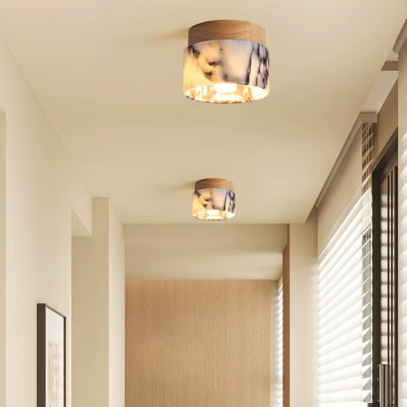 Two marble flush mount ceiling lights lit along a hallway ceiling