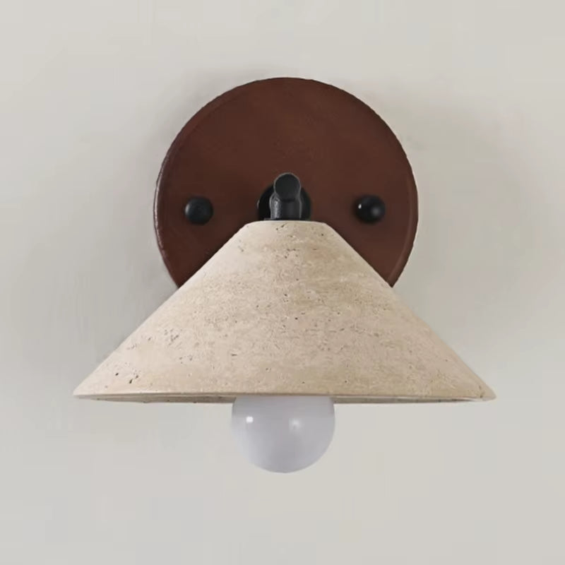 Travertine cone wall sconce on a black iron arm with a round dark wood backplate, front view