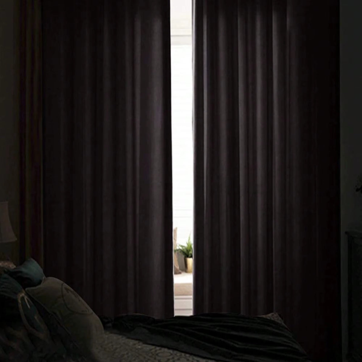 Black velvet curtain panels drawn across a bedroom window.