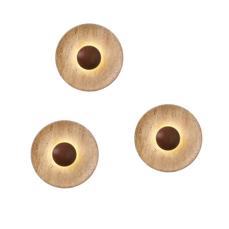 Three round stone disc wall sconces with dark wood centers, lit, on a white background.