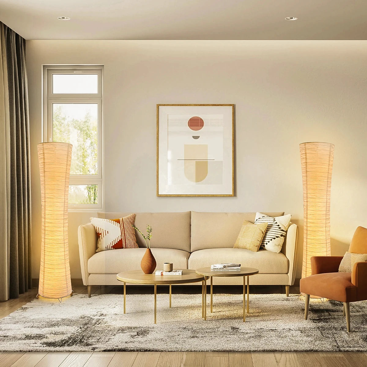Rice paper column floor lamps lit on both sides of a cream sofa in a bright living room.