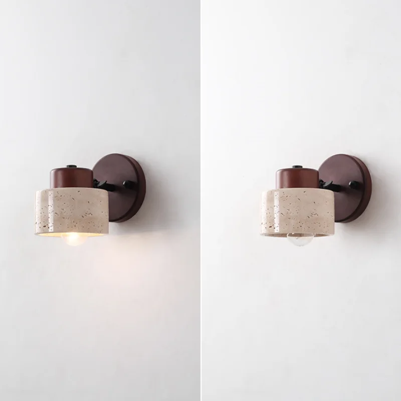 Travertine drum wall sconce lit and unlit on a white wall