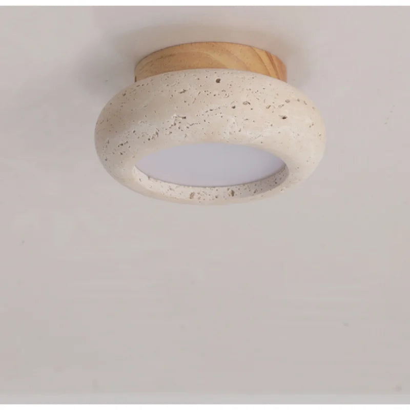 Rounded travertine flush mount ceiling light with the light wood canopy, close view