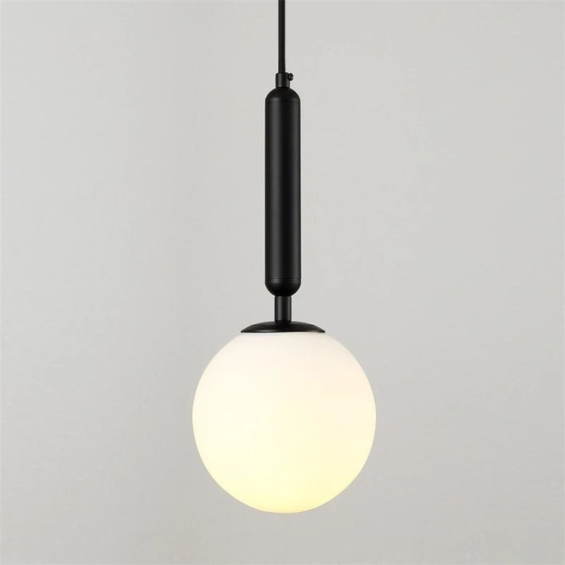 Close view of the frosted glass globe and black metal rod of the wall sconce.