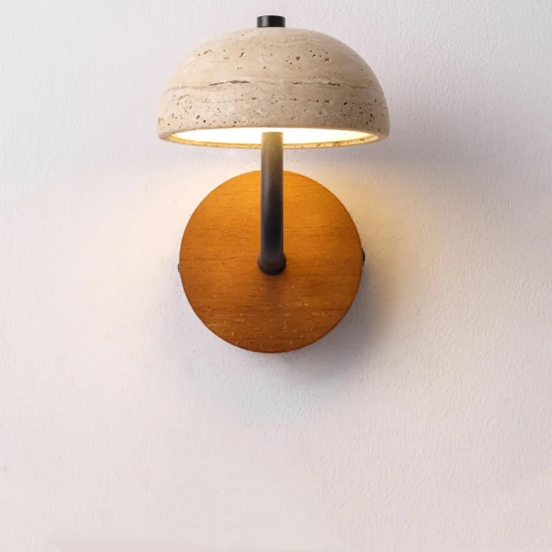 Travertine dome wall sconce on a white wall, front view