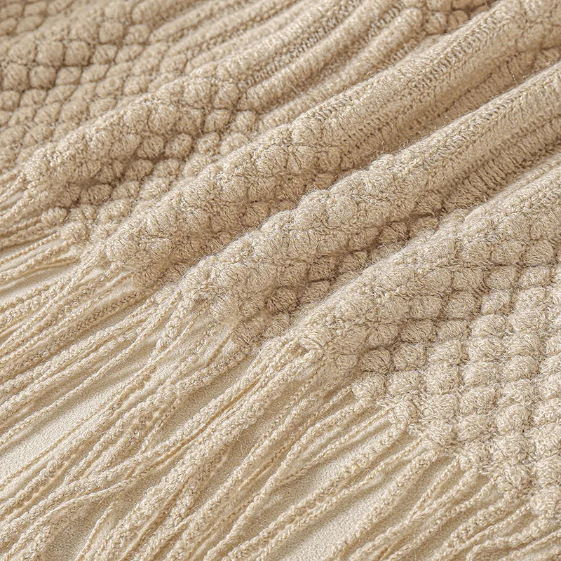 Close view of the ribbed knit texture of the khaki throw.