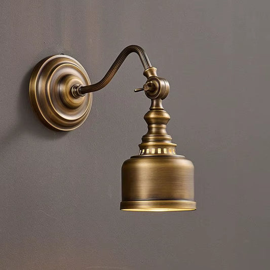 Brass wall sconce with brass shade and curved arm