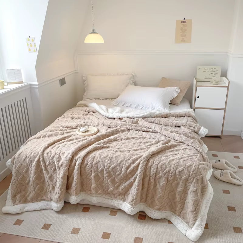 Light coffee sherpa throw blanket spread over a bed in a bedroom.