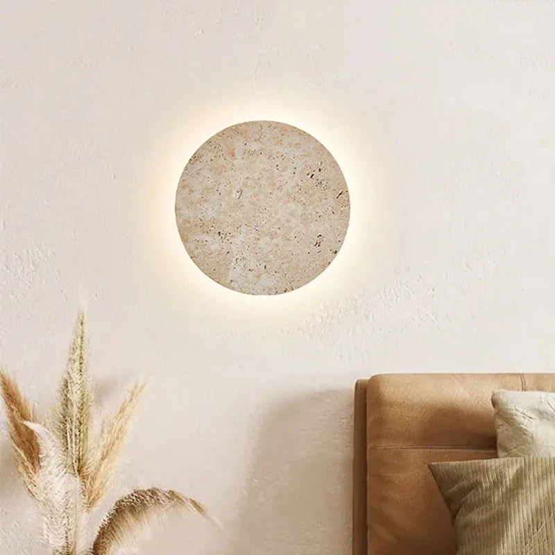 Stone disc wall sconce above a sofa