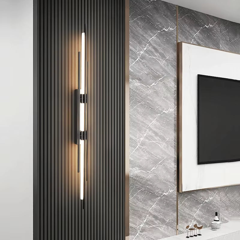Linear black wall sconce lit on a slatted wall panel