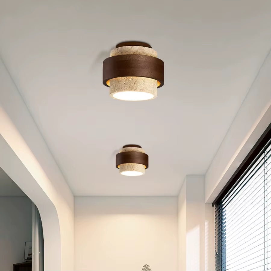 Two stepped travertine ceiling lights lit along a corridor