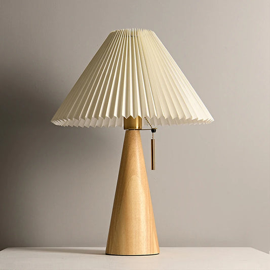Natural wood cone table lamp with a pleated fabric shade, front view.