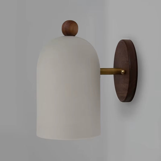 White bell shade wall sconce with a round walnut-color wood backplate