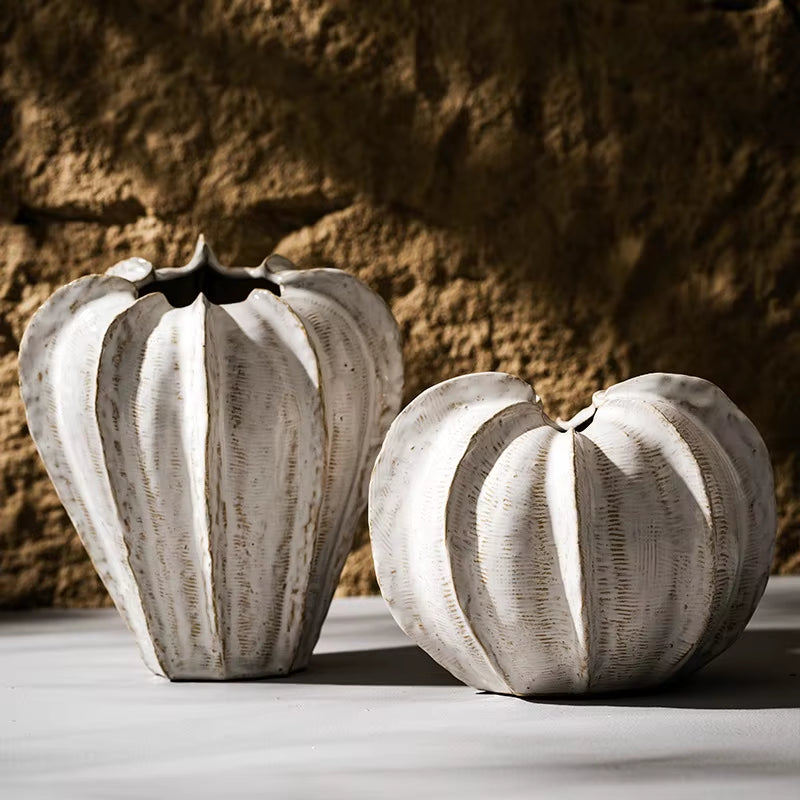Tall and round ribbed ceramic pod vases shown empty, side by side.