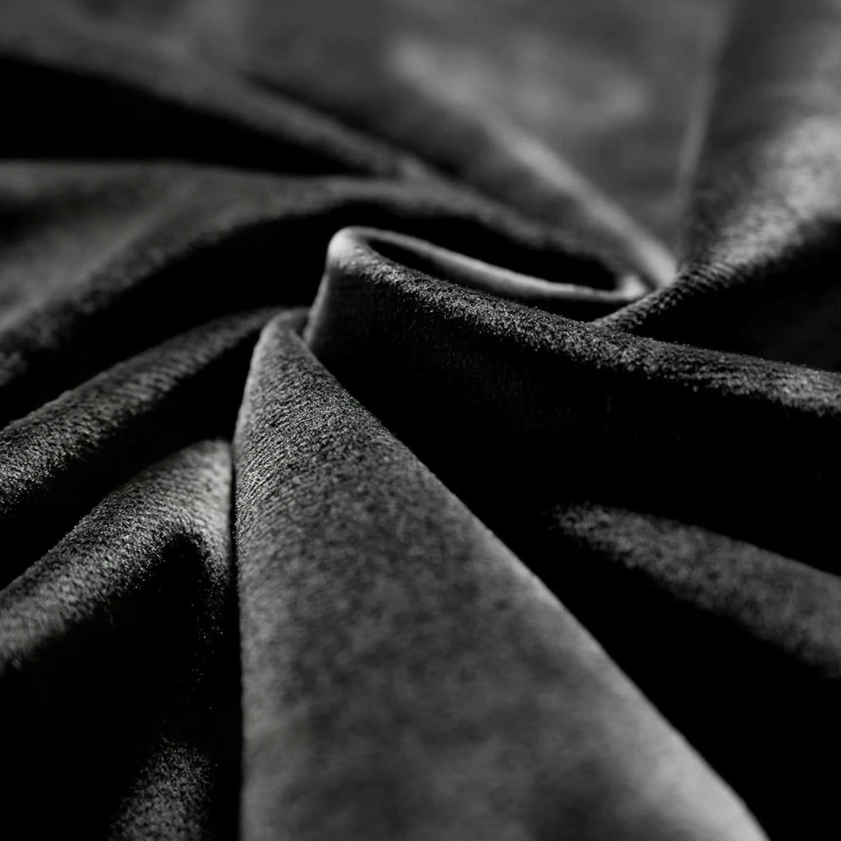 Close view of the soft black velvet fabric in folds.