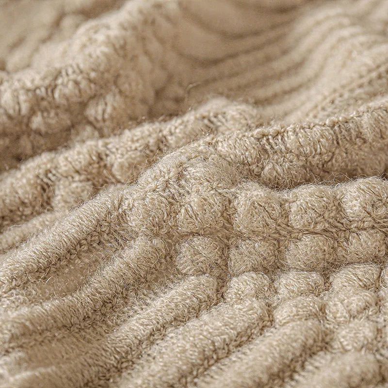 Close view of the bubble-knit band on the khaki throw.